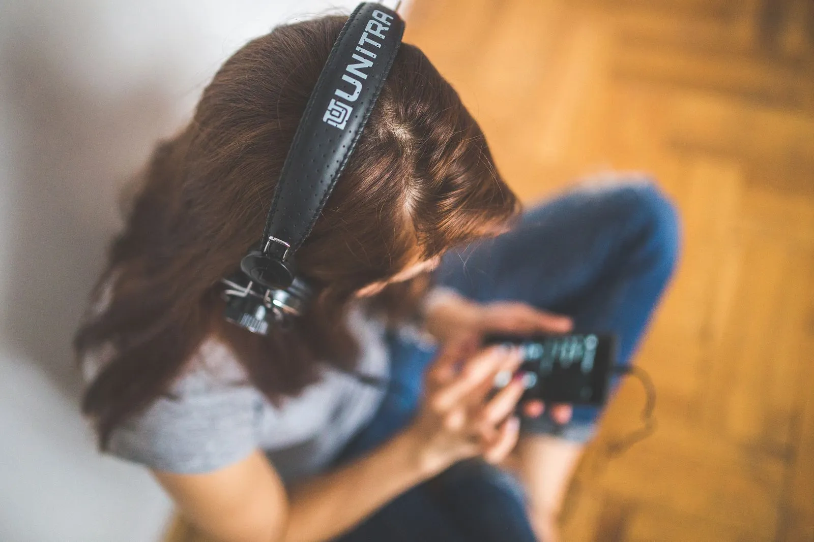 Person listening to music through headphones on a smartphone